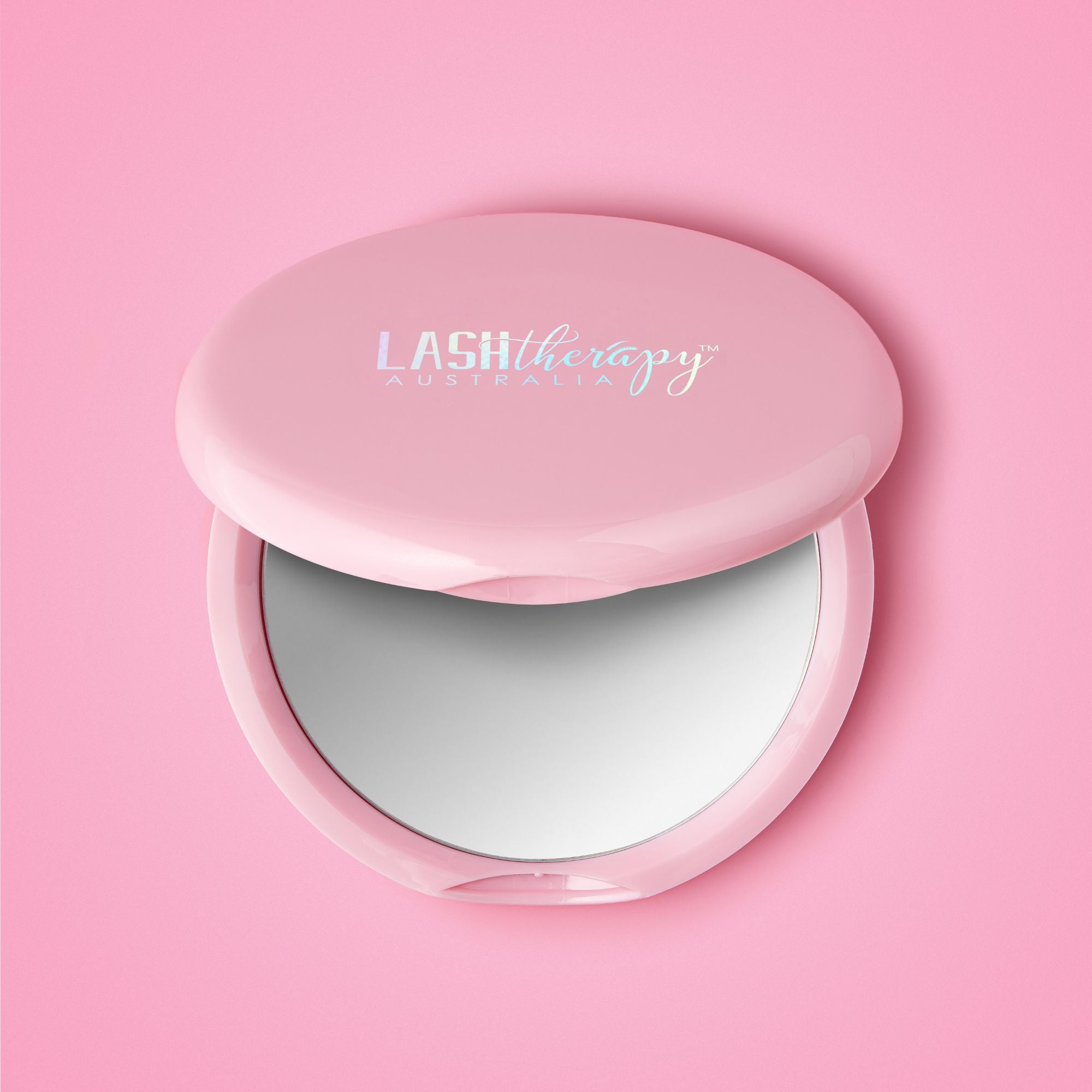 Pink compact mirror with 'LASH therapy Australia' branding on a pink background